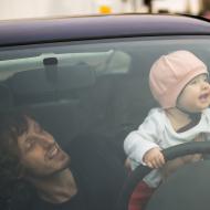 Tatínek dohlíží na správné držení volantu, Verunka by ho ale stejně nejradši ohryzala