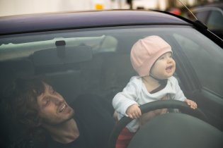 Tatínek dohlíží na správné držení volantu, Verunka by ho ale stejně nejradši ohryzala
