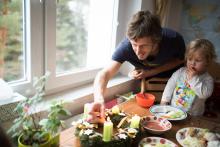 Tom, vědouc, že je focen, se při zapalování třetí svíčky na adventním věnci poctivě usmívá