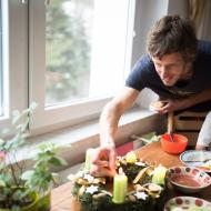 Tom, vědouc, že je focen, se při zapalování třetí svíčky na adventním věnci poctivě usmívá