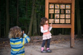 Paní učitelka při výkladu, žáček si vypomáhá dalekohledem, aby mu nici neuniklo