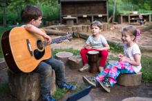 Pátek večer- školkový táborák, Ráďa zjišťuje, že s kytarou na klíně je hnedle středem pozornosti