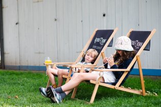 Zatímco Ráďa leží opodál na karimatce ve spacáku, jeho sourozenci si chillují v lehátkách